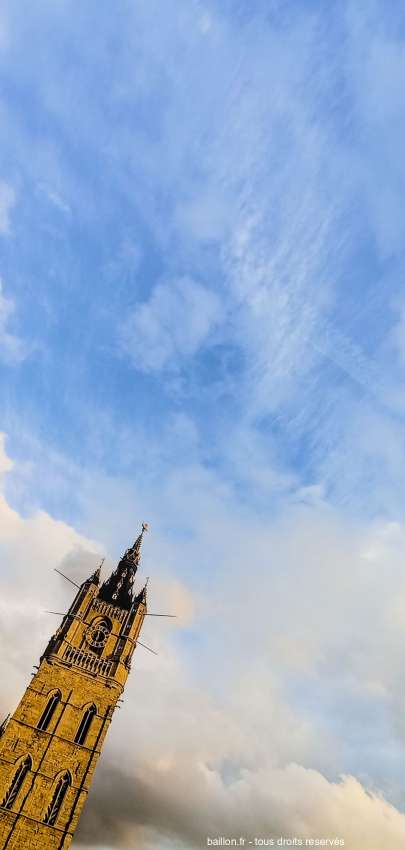Beffroi de Gand en Belgique sur fond de nuage et ciel bleu.